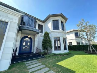 Elegant two-story house with blue front door and green lawn