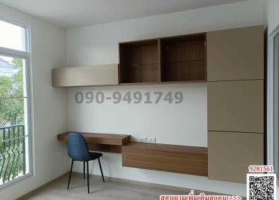 Compact bedroom with built-in desk and shelving units