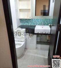 Compact bathroom with white fixtures and green tiled backsplash