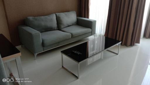 Modern living room with gray sofa and glass coffee table