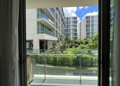 View from a balcony overlooking a modern apartment complex with green landscaping