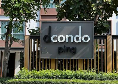Condo building sign surrounded by greenery