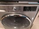 Front-loading silver washing machine in a modern laundry room