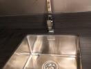 Modern stainless steel kitchen sink with a high faucet