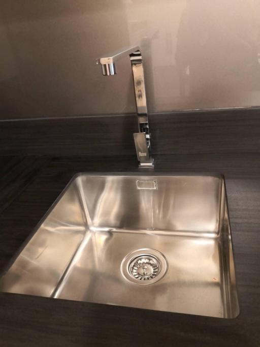 Modern stainless steel kitchen sink with a high faucet