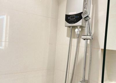 Modern bathroom interior with wall-mounted shower system, including rainfall showerhead and adjustable handheld shower