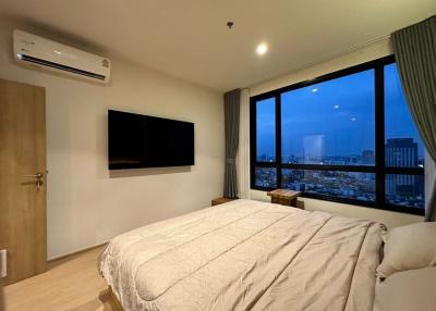 Modern bedroom with large windows and city view