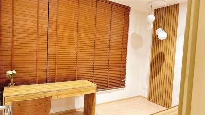 Well-lit home office space with wooden desk and stylish blinds