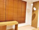 Well-lit home office space with wooden desk and stylish blinds