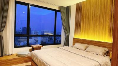 Modern bedroom with large window and cityscape view