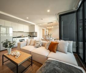 Modern open concept living room with kitchen view and ample natural light