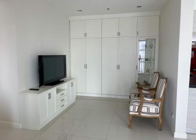 Modern living room with large white cabinet, flat-screen TV, and comfortable seating