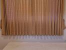 Neatly presented bedroom with large window dressed with patterned curtains