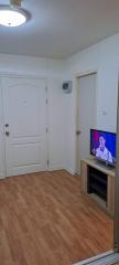 Living room with wooden floors and a television set