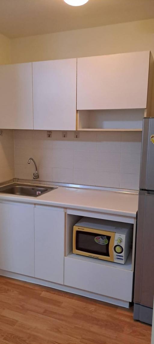 Compact kitchen with white cabinetry and modern appliances