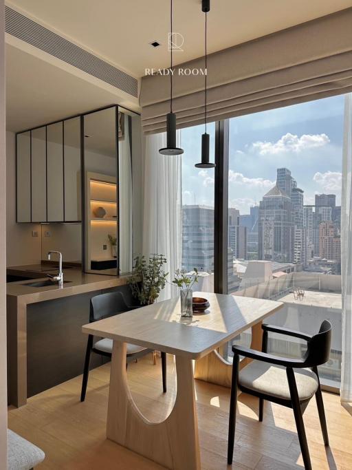 Modern kitchen with dining area and city view through floor-to-ceiling windows