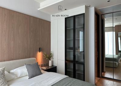 Contemporary bedroom with wooden accent wall and floor-to-ceiling glass wardrobe