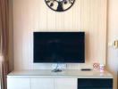 Modern living room with wall-mounted television and wooden backdrop