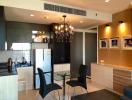 Modern kitchen with adjacent dining area featuring a chandelier, stainless steel appliances, and wooden cabinets