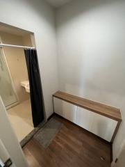 Compact hallway with a wooden bench and view into the bathroom