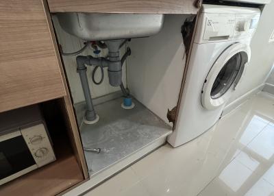 Modern utility room with built-in cabinetry and washing machine