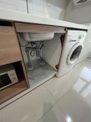 Modern utility room with built-in cabinetry and washing machine