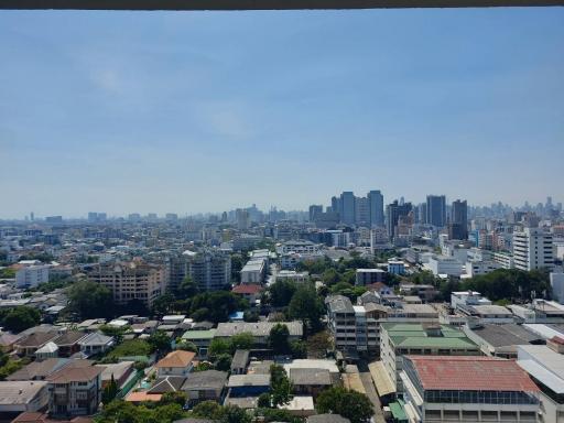 Expansive cityscape view from the balcony showing a clear blue sky and urban surroundings