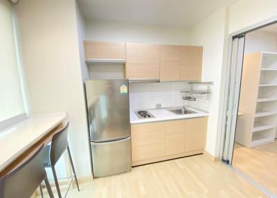 Compact modern kitchen with stainless steel appliances and light wood cabinetry