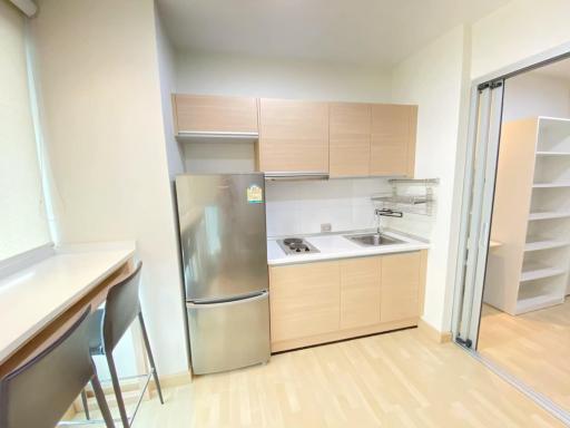 Compact modern kitchen with stainless steel appliances and light wood cabinetry