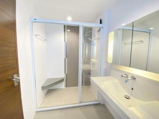 Modern bathroom interior with glass shower and white sink