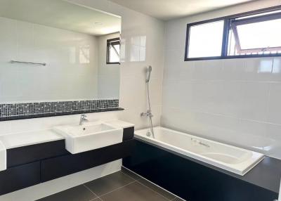 Modern bathroom with dual sinks, bathtub, and separate shower area