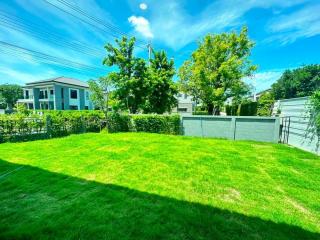 Spacious backyard with green lawn and clear blue sky