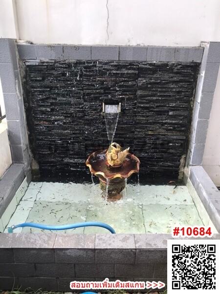 Decorative outdoor water fountain with black tiles