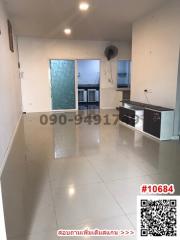 Empty open space with kitchenette and tiled flooring in a modern apartment