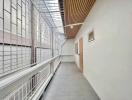 Bright and airy indoor hallway with large windows and a wooden ceiling