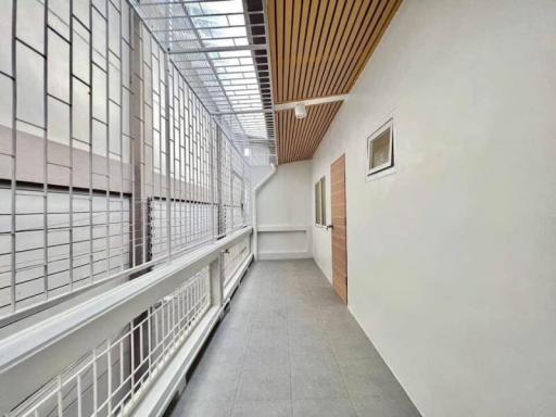 Bright and airy indoor hallway with large windows and a wooden ceiling