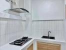 Modern white kitchen with stainless steel stove and black sink