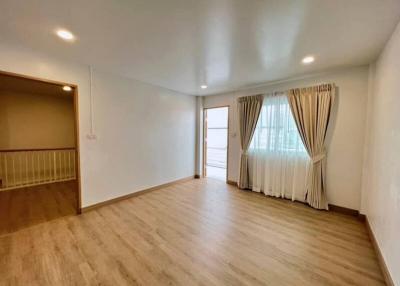 Spacious living room with hardwood floors and natural light