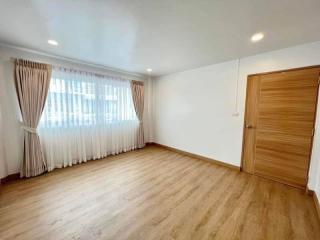 Spacious unfurnished bedroom with large window and hardwood flooring