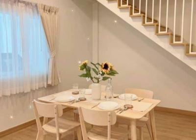 Cozy minimalist dining room with a wooden table, chairs and stylish staircase