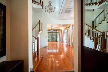 Spacious and elegant entryway with hardwood floors and staircase