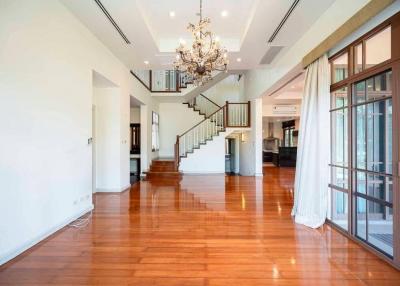 Spacious interior of a modern home with elegant wooden flooring and a grand staircase