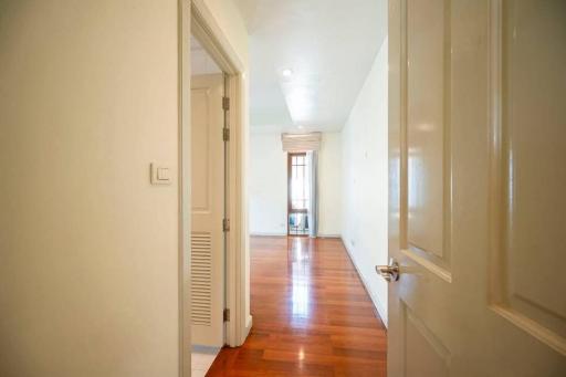 Bright corridor with hardwood flooring leading to rooms
