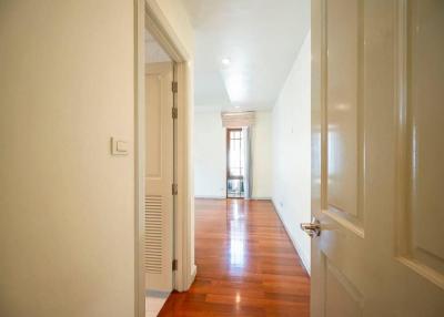 Bright corridor with hardwood flooring leading to rooms