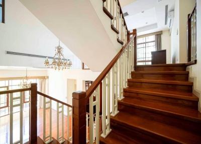 Elegant wooden staircase with white balustrades and high ceiling