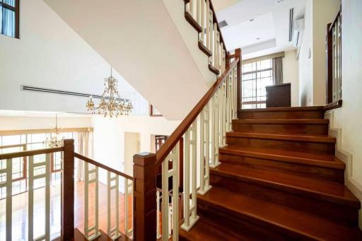 Elegant wooden staircase with white balustrades and high ceiling