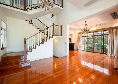 Spacious living room with wooden floors, staircase and large windows