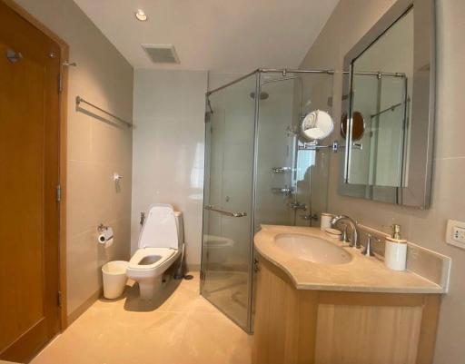 Modern bathroom with glass shower enclosure, toilet, and vanity
