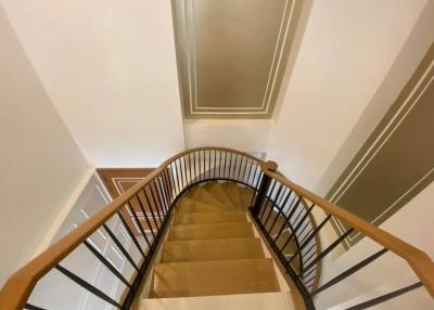 Upward view of a modern staircase with wooden handrails and clean lines