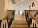 Modern staircase with elegant finishes leading to an upper-level living space with ample lighting